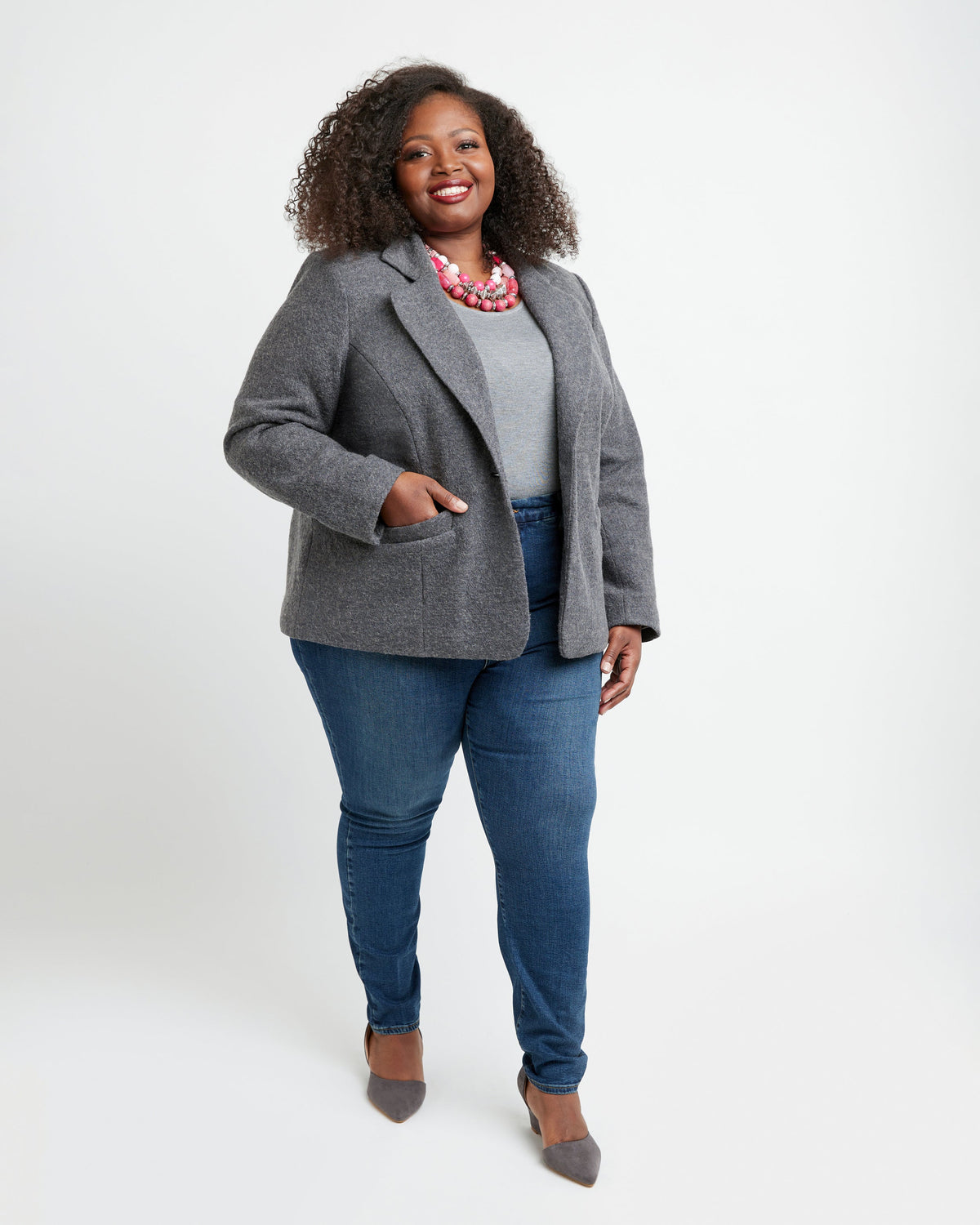 Woman wearing a gray blazer, white shirt, and blue jeans on a white background. This blazer is the Auburn Blazer sewing pattern from Cashmerette.