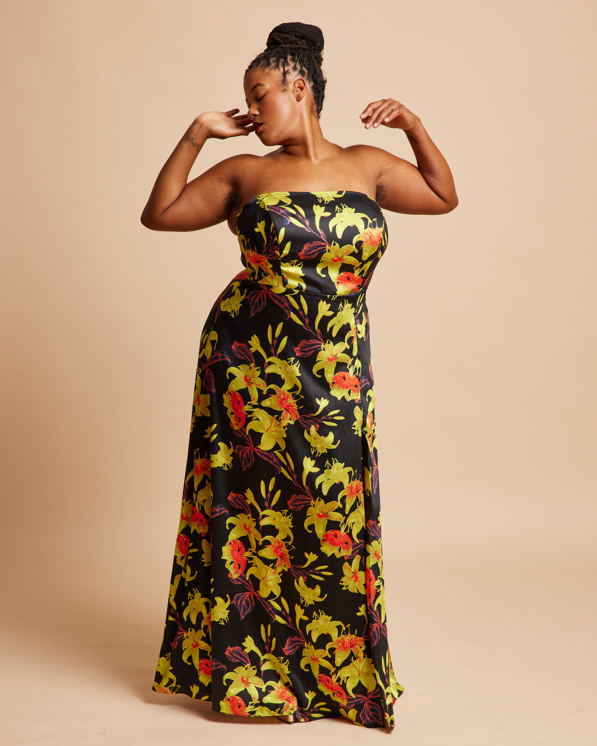 Woman wearing a strapless floral dress on a beige background. This dress is the Ellington Strapless Dress sewing pattern from Cashmerette.