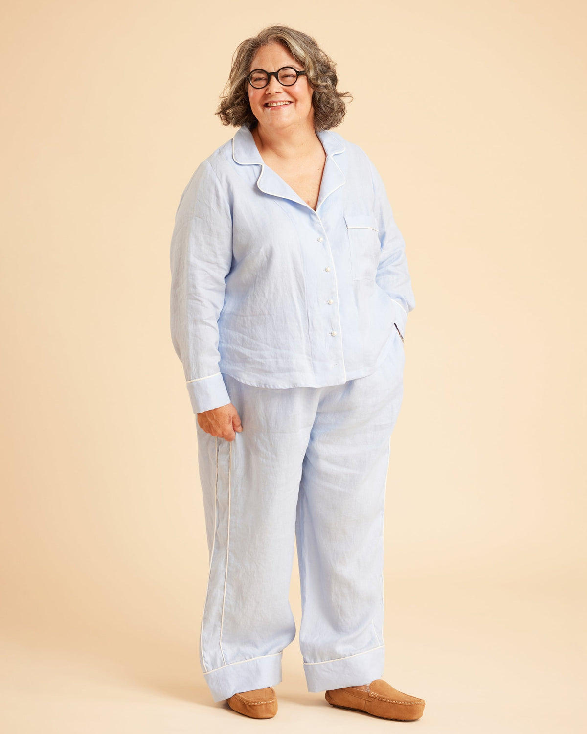 Person wearing a light blue pajama set on a beige background. This is the Fiske Sleepwear Set sewing pattern from Cashmerette.