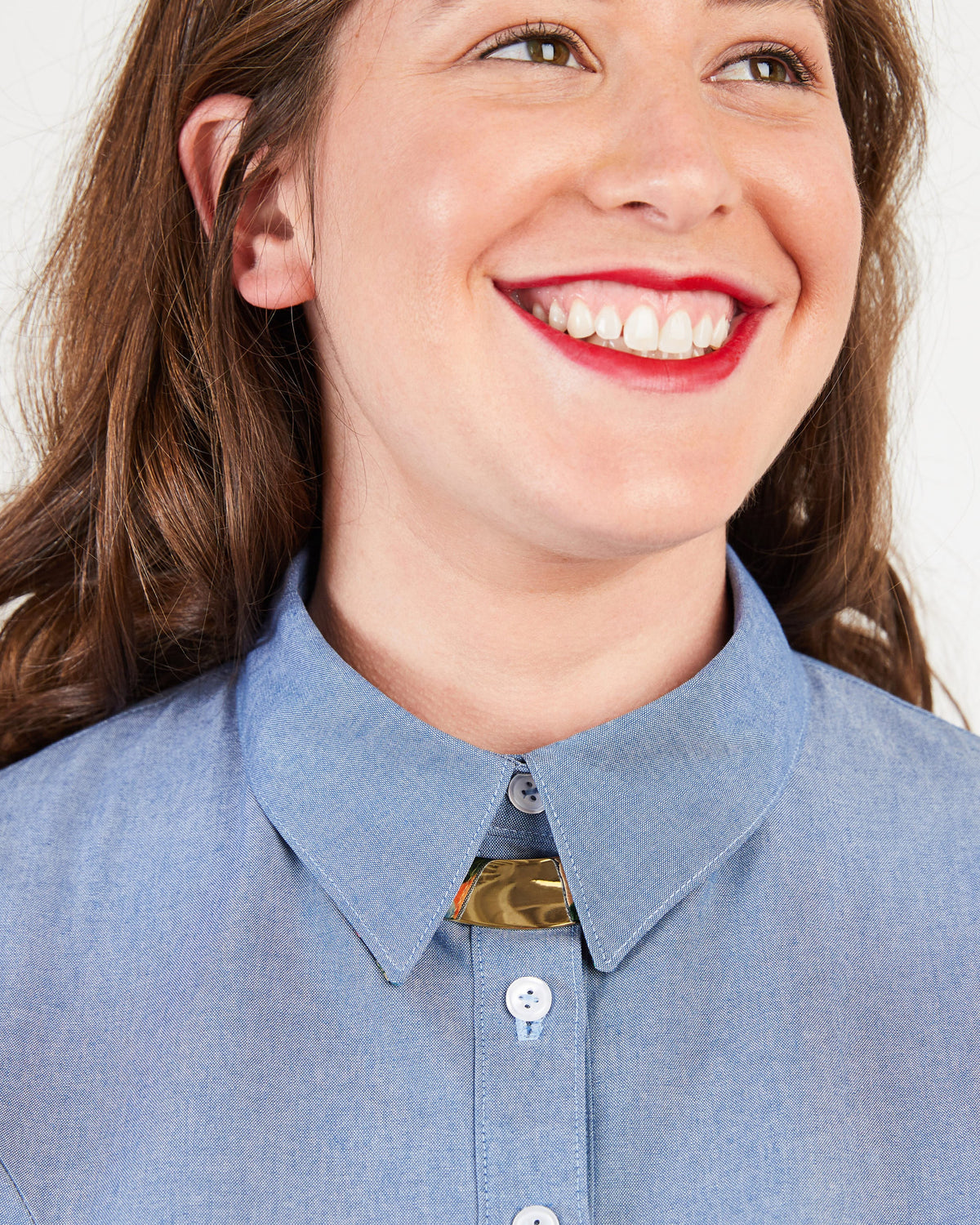 Close-up of a person wearing a blue shirt with a collar. This button-up shirt is the Harrison Shirt sewing pattern from Cashmerette.