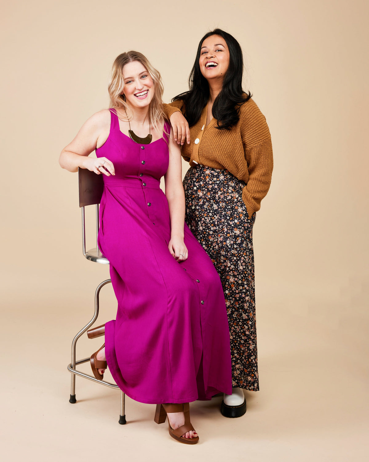 Two women posing together on a beige background. This is the Holyoke Maxi Dress & Skirt sewing pattern from Cashmerette.