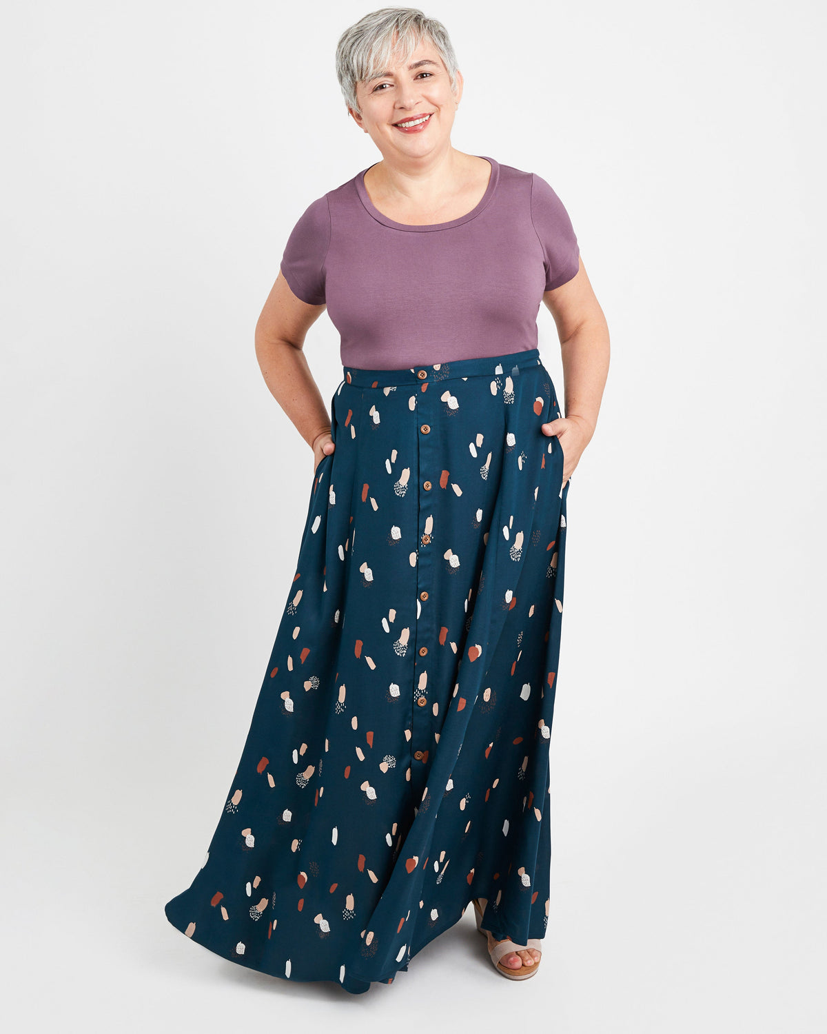 Woman wearing a purple top and navy patterned pants on a white background. This is the Holyoke Maxi Dress & Skirt sewing pattern from Cashmerette.