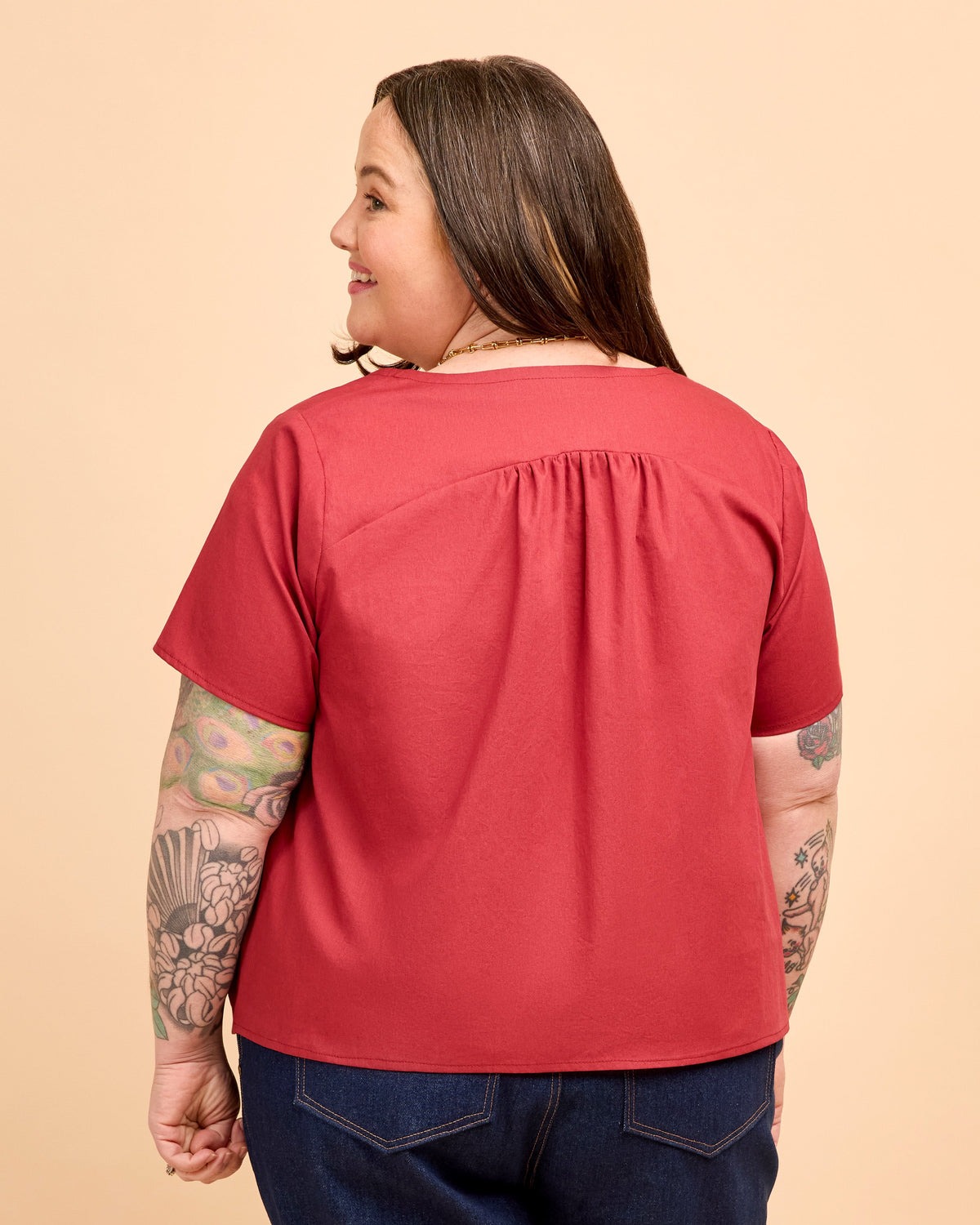Person wearing a red shirt on a beige background. This is the Montrose Top sewing pattern from Cashmerette.