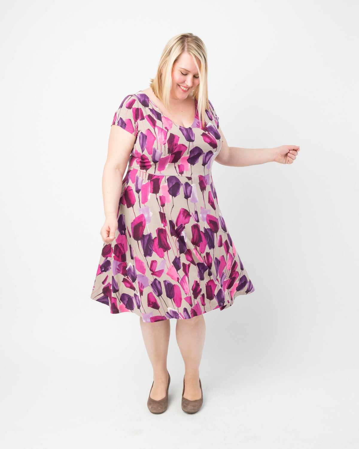 Woman wearing a floral dress on a white background. This dress is the Turner Dress sewing pattern from Cashmerette.