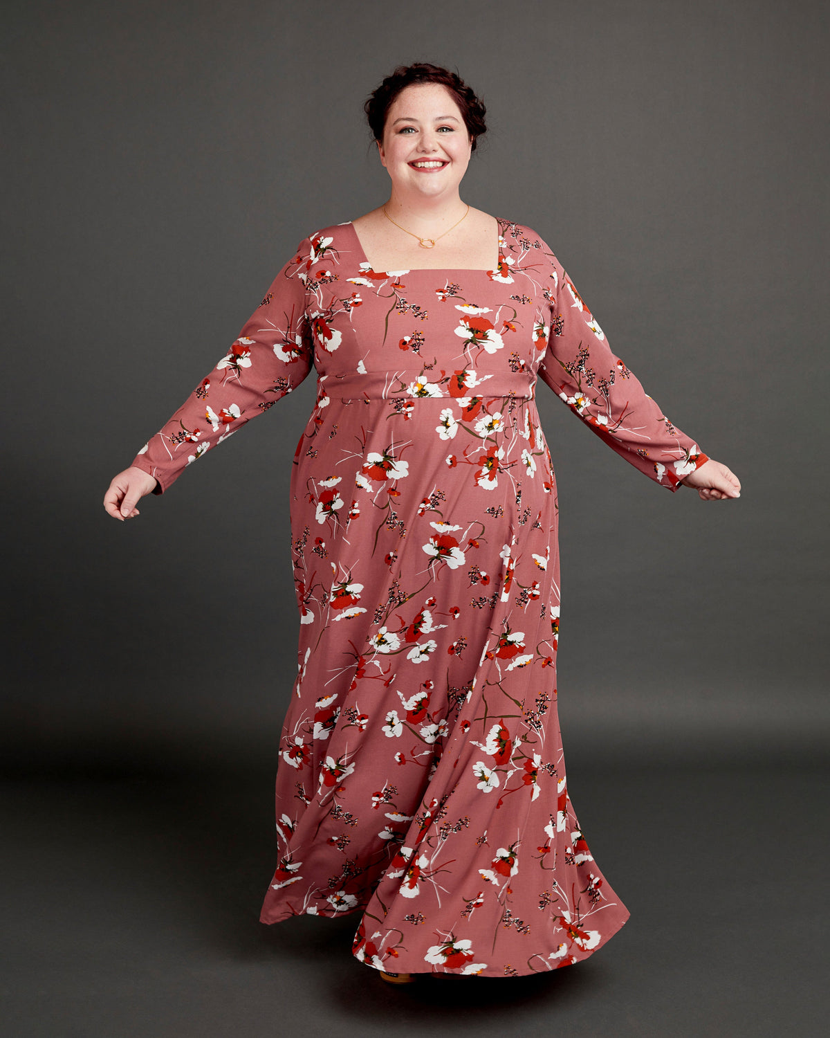 Woman wearing a long floral dress against a gray background. This dress is the Upton Dress & Skirt sewing pattern from Cashmerette.