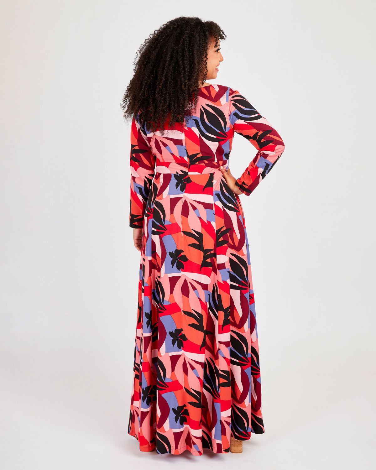 Woman wearing a colorful patterned dress on a white background. This dress is the Upton Dress & Skirt sewing pattern from Cashmerette.