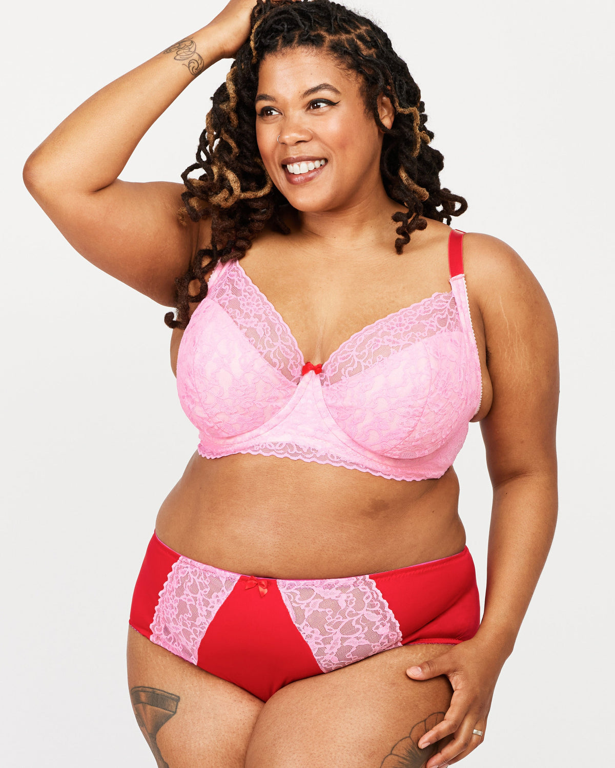 Woman wearing a pink and red lingerie set on a white background. This bra is the Willowdale Bra sewing pattern from Cashmerette.