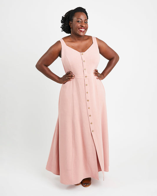 Woman wearing a pink sleeveless dress with buttons on a white background. This is the Holyoke Maxi Dress & Skirt sewing pattern from Cashmerette.