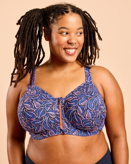 Woman wearing a blue patterned bra against a beige background. This is the Cashmerette Somerville Sports Bra sewing pattern for big boobs.