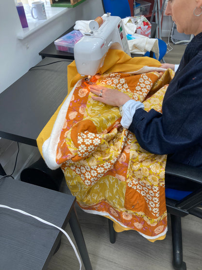 sarah quilting strawflower in oranges.jpeg