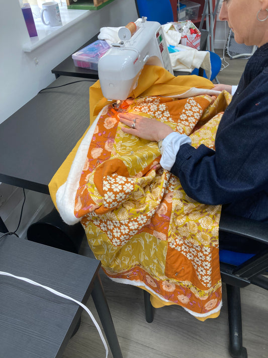 sarah quilting strawflower in oranges.jpeg