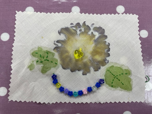 flower and leaf imprints with embroidery and a string of beads
